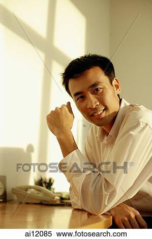 Executive sitting, arms on desk, looking at camera View Large Photo Image Stock Photography - Executive sitting, arms on desk, looking at camera. Fotosearch