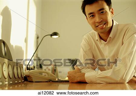 Executive sitting at desk, arms crossed View Large Photo Image Stock Image - Executive sitting at desk, arms crossed. Fotosearch