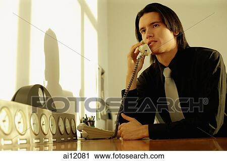 Executive sitting at desk, on the phone View Large Photo Image Stock Image - Executive sitting at desk, on the phone. Fotosearch