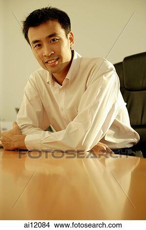 Executive sitting at desk, portrait View Large Photo Image Picture - Executive sitting at desk, portrait. Fotosearch