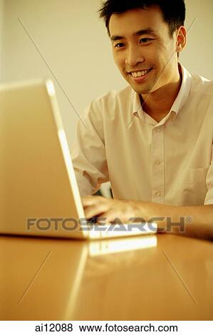 Executive using laptop, looking forward, toothy smile View Large Photo Image Stock Photo - Executive using laptop, looking forward, toothy smile. Fotosearch