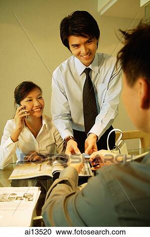 Executives having a discussion, woman using mobile phone View Large Photo Image Stock Image - Executives having a discussion, woman using mobile phone. Fotosearch