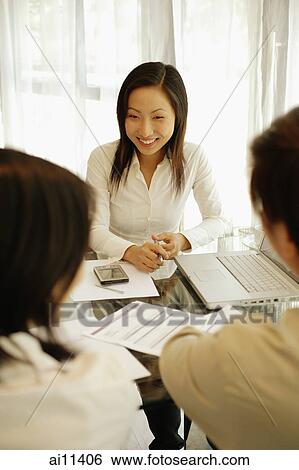 Executives sitting across the table, talking. View Large Photo Image Stock Photograph - Executives sitting across the table, talking.. Fotosearch
