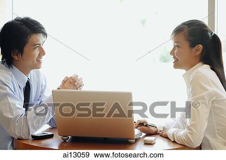 Executives sitting and talking, laptop between them View Large Photo Image Stock Photo - Executives sitting and talking, laptop between them. Fotosearch