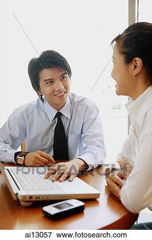 Executives sitting, talking, laptop and PDA on table View Large Photo Image Stock Photo - Executives sitting, talking, laptop and PDA on table. Fotosearch