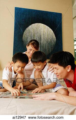 Family at home, playing with jigsaw puzzle. View Large Photo Image Stock Photo - Family at home, playing with jigsaw puzzle.. Fotosearch