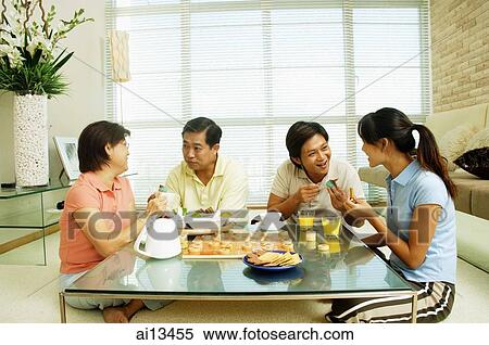 Family sitting in living room, relaxing View Large Photo Image Stock Photography - Family sitting in living room, relaxing. Fotosearch