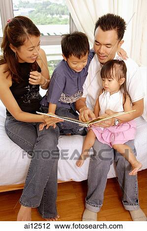 Family sitting together, looking at book View Large Photo Image Stock Image - Family sitting together, looking at book. Fotosearch