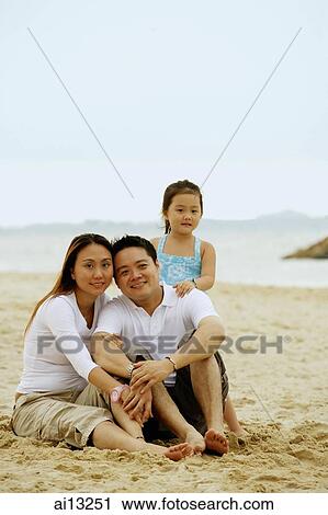 Family with one child, on the beach, looking at camera View Large Photo Image Stock Image - Family with one child, on the beach, looking at camera. Fotosearch