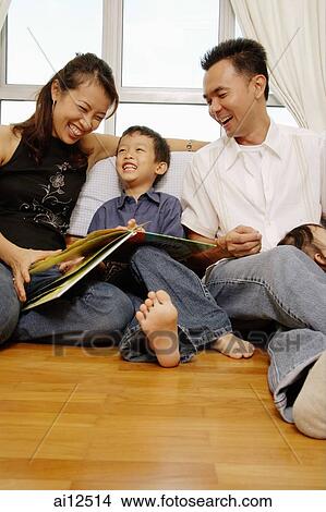 Family with one son sitting together, looking at book View Large Photo Image Picture - Family with one son sitting together, looking at book. Fotosearch