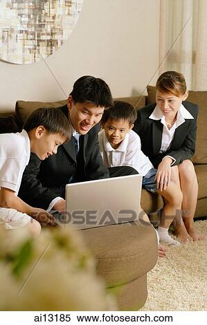 Family with two children at home using laptop View Large Photo Image Stock Photography - Family with two children at home using laptop. Fotosearch