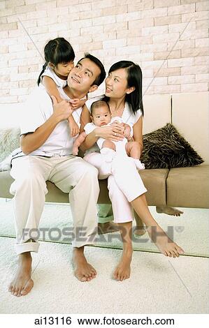 Family with two children in living room View Large Photo Image Stock Photograph - Family with two children in living room. Fotosearch