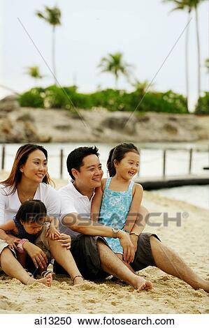 Family with two children on the beach, sitting on sand, looking away View Large Photo Image Stock Image - Family with two children on the beach, sitting on sand, looking away. Fotosearch