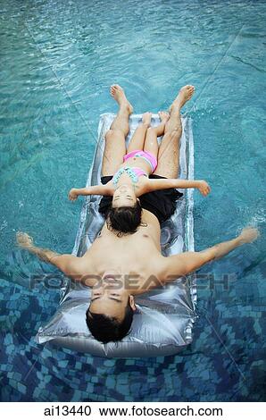 Father and daughter on inflatable bed in swimming pool View Large Photo Image Stock Image - Father and daughter on inflatable bed in swimming pool. Fotosearch
