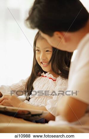 Father and daughter, sitting side by side, book between them View Large Photo Image Stock Photo - Father and daughter, sitting side by side, book between them. Fotosearch