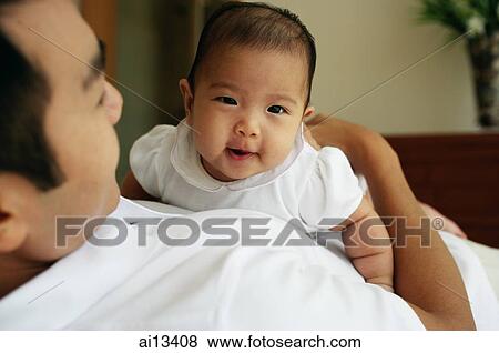 Father carrying baby daughter, high angle view View Large Photo Image Stock Photo - Father carrying baby daughter, high angle view. Fotosearch