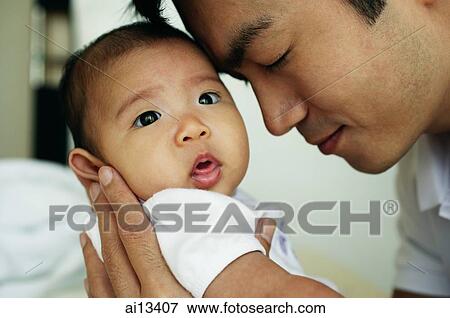 Stock Photo - Father carrying baby daughter. Fotosearch