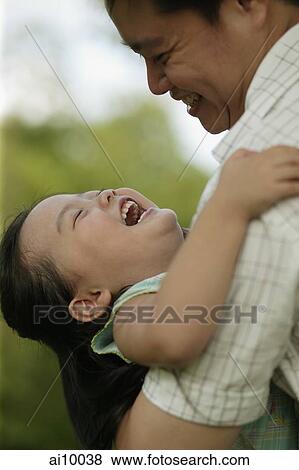 Father carrying young daughter, looking down View Large Photo Image Stock Photo - Father carrying young daughter, looking down. Fotosearch