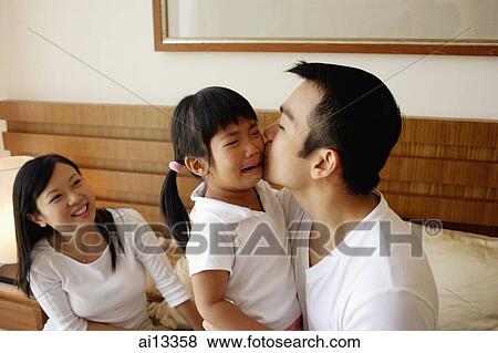 Father kissing crying daughter, mother looking on View Large Photo Image Stock Photo - Father kissing crying daughter, mother looking on. Fotosearch
