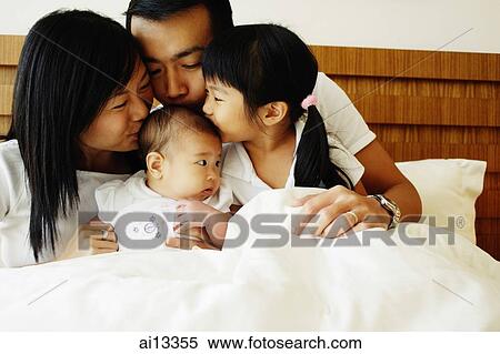 Father, mother and daughter kissing baby View Large Photo Image Stock Photography - Father, mother and daughter kissing baby. Fotosearch