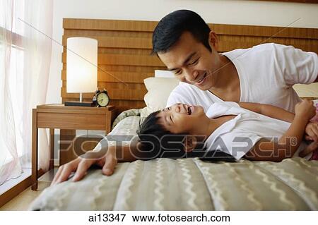 Father with daughter, laughing on bed View Large Photo Image Stock Photo - Father with daughter, laughing on bed. Fotosearch