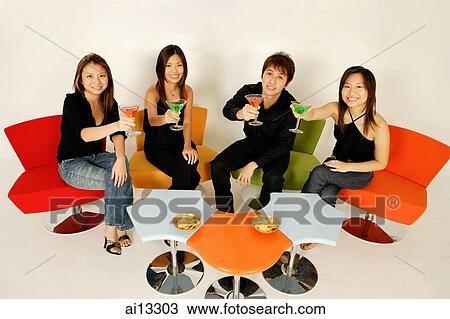Four adults sitting down, raising cocktails, looking at camera View Large Photo Image Stock Image - Four adults sitting down, raising cocktails, looking at camera. Fotosearch