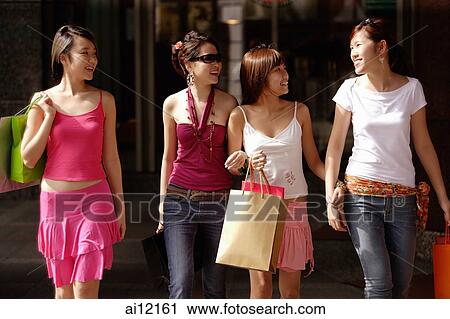 Four young women, walking side by side, carrying shopping bags View Large Photo Image Stock Image - Four young women, walking side by side, carrying shopping bags. Fotosearch
