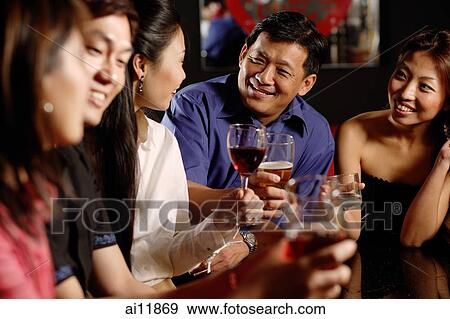 Friends having drinks at bar View Large Photo Image Stock Photo - Friends having drinks at bar. Fotosearch