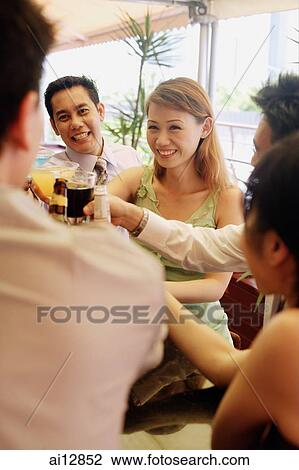 Friends raising drinks for a toast View Large Photo Image Stock Image - Friends raising drinks for a toast. Fotosearch