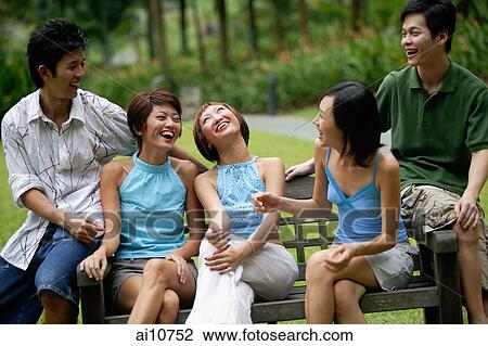 Friends sitting side by side on park bench, laughing View Large Photo Image Stock Image - Friends sitting side by side on park bench, laughing. Fotosearch