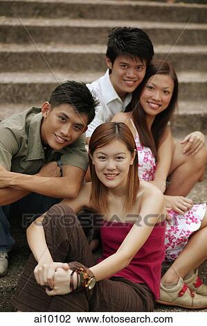 Friends sitting together, looking at camera View Large Photo Image Stock Image - Friends sitting together, looking at camera. Fotosearch