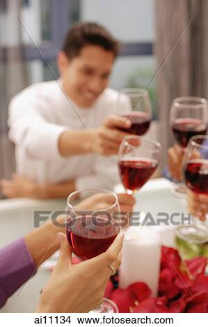 Friends toasting with wine glasses across dinner table View Large Photo Image Picture - Friends toasting with wine glasses across dinner table. Fotosearch