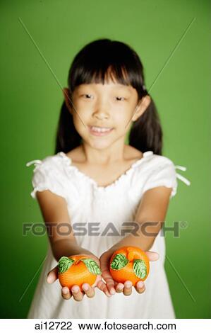 Girl holding two plastic oranges in hands View Large Photo Image Stock Image - Girl holding two plastic oranges in hands. Fotosearch
