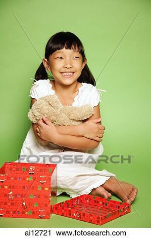 Girl hugging stuffed toy, wrapped box open in front of her View Large Photo Image Stock Image - Girl hugging stuffed toy, wrapped box open in front of her. Fotosearch