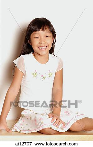 Girl sitting down, looking at camera, smiling View Large Photo Image Stock Photo - Girl sitting down, looking at camera, smiling. Fotosearch