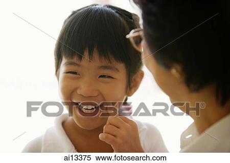 Granddaughter with finger on cheek, grandmother in front of her View Large Photo Image Stock Photography - Granddaughter with finger on cheek, grandmother in front of her. Fotosearch