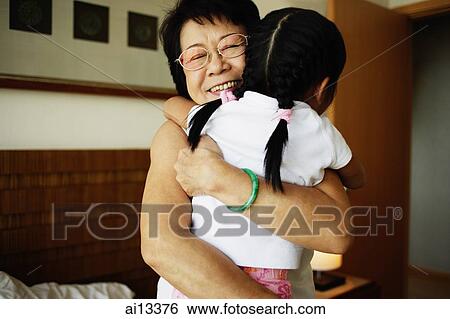 Grandmother hugging granddaughter View Large Photo Image Stock Photograph - Grandmother hugging granddaughter. Fotosearch