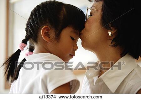 Picture - Grandmother kissing granddaughter. Fotosearch