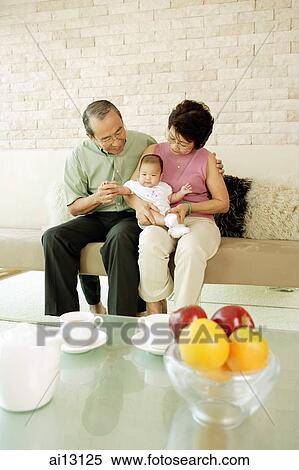 Stock Photography - Grandparents with granddaughter, looking down. Fotosearch