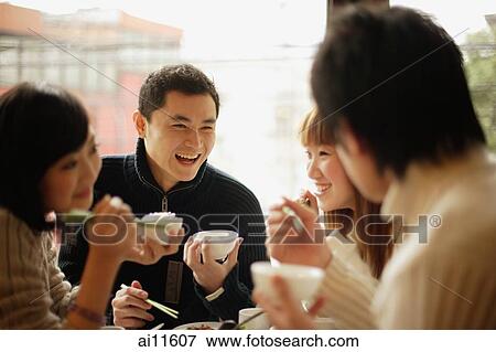 Group of friends eating at a Chinese restaurant, face to face View Large Photo Image Stock Photo - Group of friends eating at a Chinese restaurant, face to face. Fotosearch