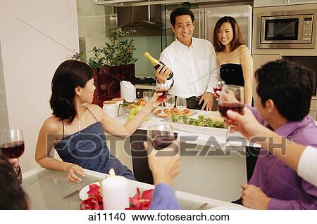 Group of friends having a dinner party at home, some raising wine glass View Large Photo Image Stock Image - Group of friends having a dinner party at home, some raising wine glass. Fotosearch
