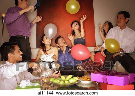 Group of friends having a party at home, playing with balloons View Large Photo Image Picture - Group of friends having a party at home, playing with balloons. Fotosearch