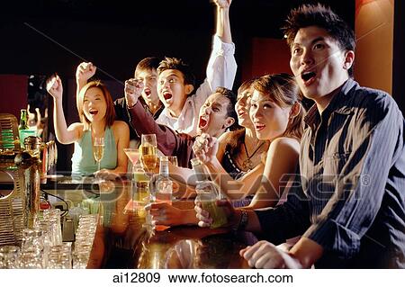 Group of friends sitting at bar, watching something View Large Photo Image Stock Photo - Group of friends sitting at bar, watching something. Fotosearch