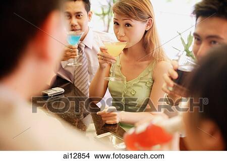 Picture - Group of young adults drinking at bar. Fotosearch