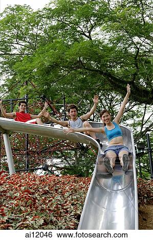 Group of young people sliding down playground slide View Large Photo Image Stock Photograph - Group of young people sliding down playground slide. Fotosearch