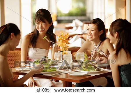 Group of young women, sitting down at cafe, eating and talking View Large Photo Image Stock Image - Group of young women, sitting down at cafe, eating and talking. Fotosearch