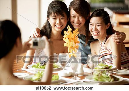 Group of young women, sitting down at cafe, posing for camera View Large Photo Image Stock Image - Group of young women, sitting down at cafe, posing for camera. Fotosearch