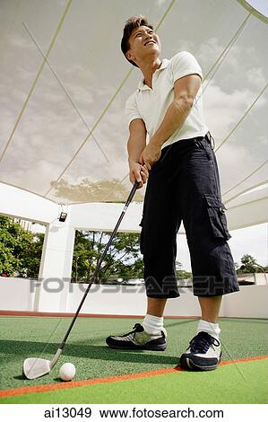 Man at driving range, preparing to swing View Large Photo Image Stock Photo - Man at driving range, preparing to swing. Fotosearch