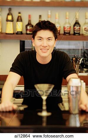 Man behind bar counter, glass and mixer in front of him View Large Photo Image Picture - Man behind bar counter, glass and mixer in front of him. Fotosearch