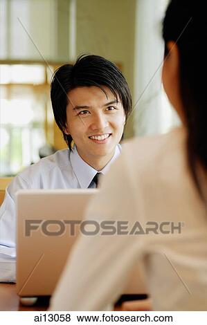Stock Photo - Man facing woman, over the shoulder view. Fotosearch